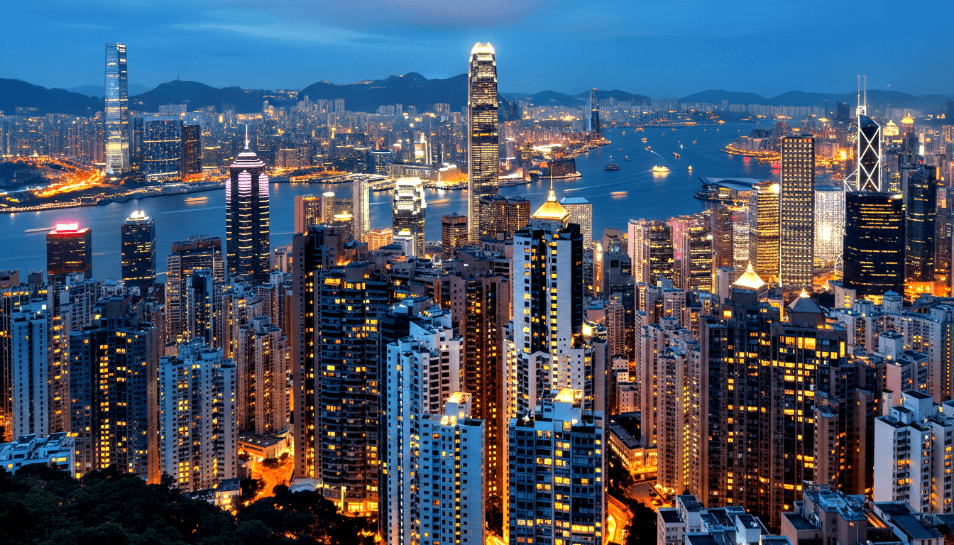 Blue-hour skyline: dense skyscrapers, amber-lit windows, wide harbor, X-braced tower right, crown-lit tower center-left, hills behind.